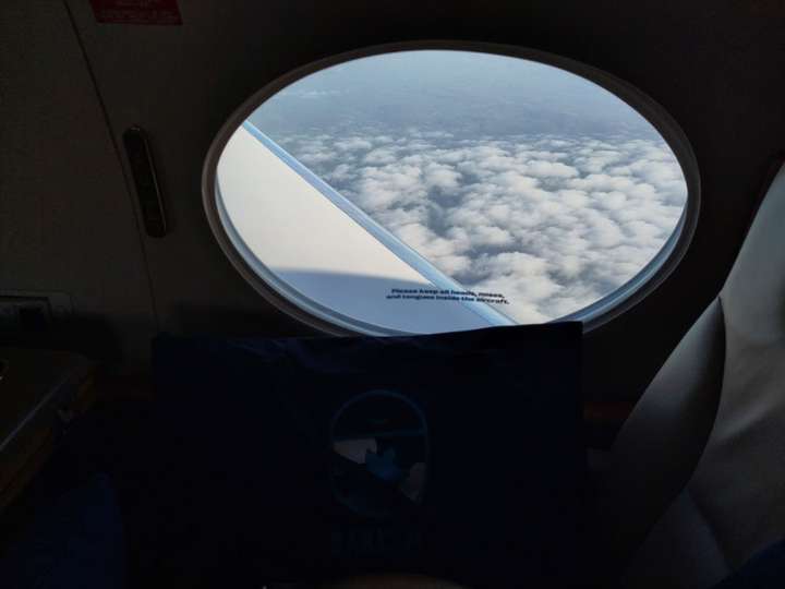 View of clouds outside small airplane window