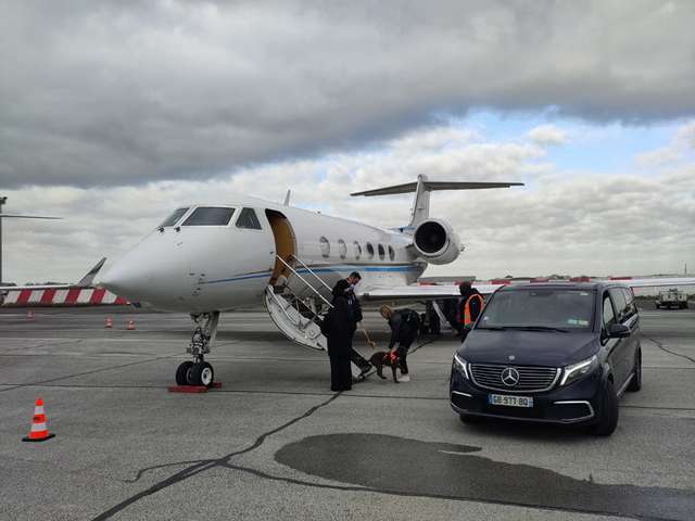 Gulfstream jet on runway beside Mercedes Benz van